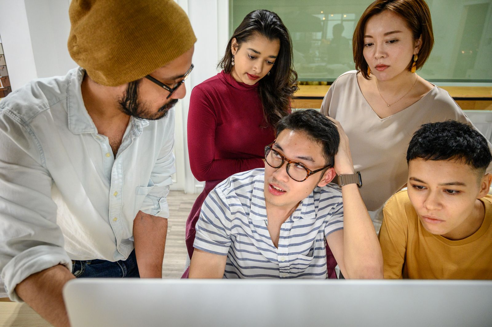Growing business team collaborating around a computer